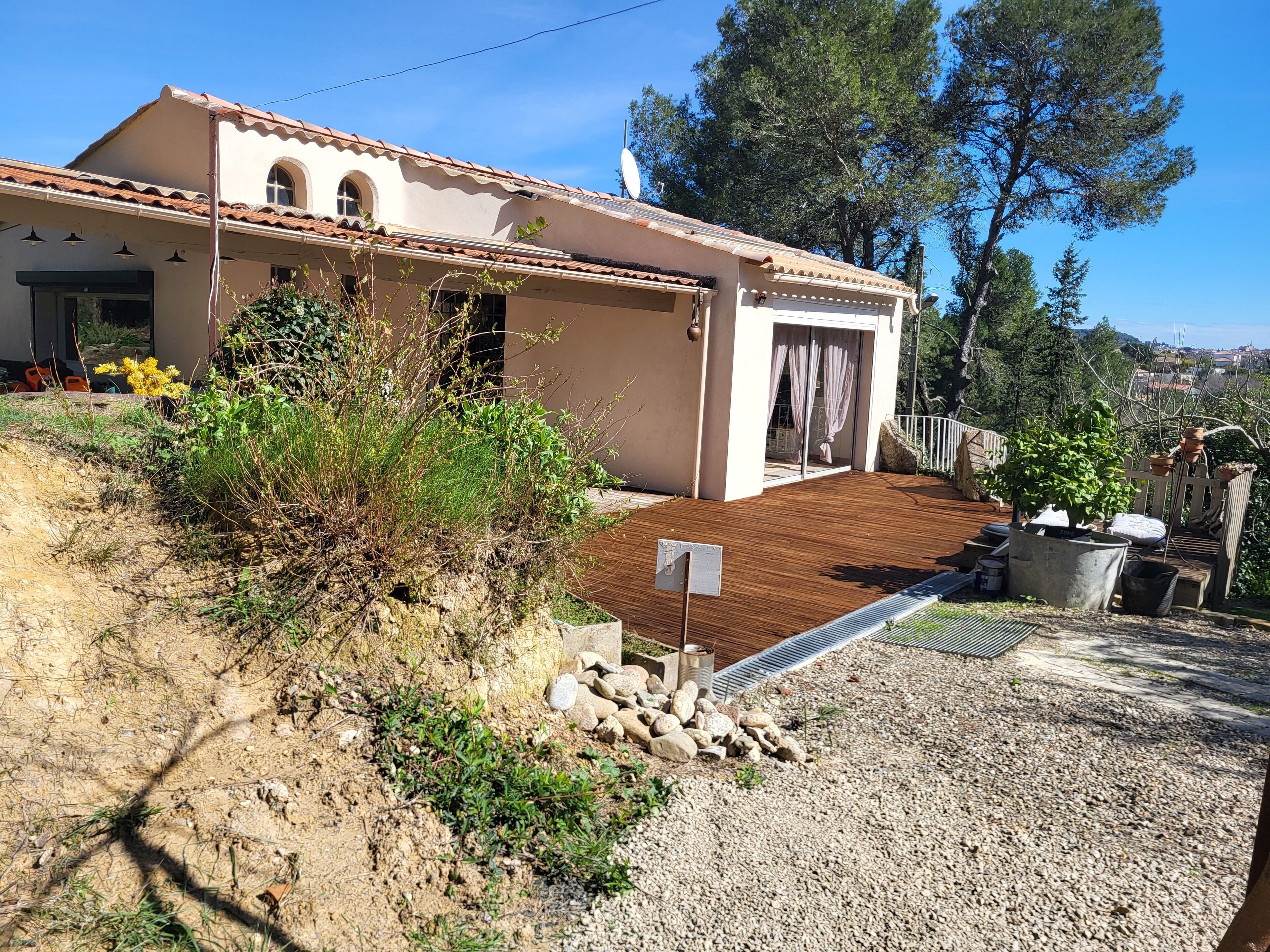 Una casa con tetto in tegole, veranda in legno e vialetto in ghiaia.