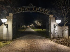 A gated entrance with a sign reading "MORAC JURFEE" at night.