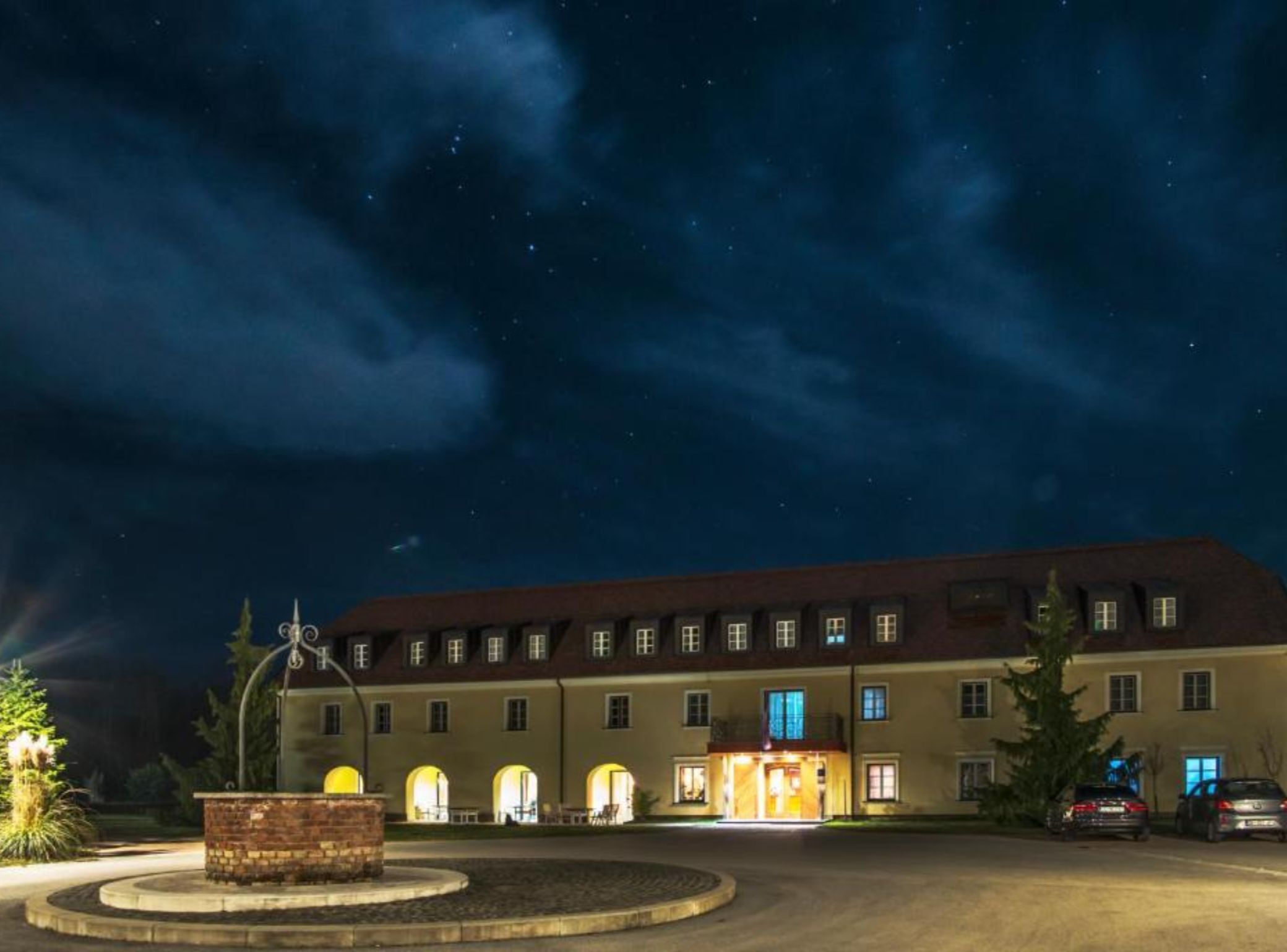 Un hotel grande con varios pisos, una entrada central y una fachada bien iluminada.