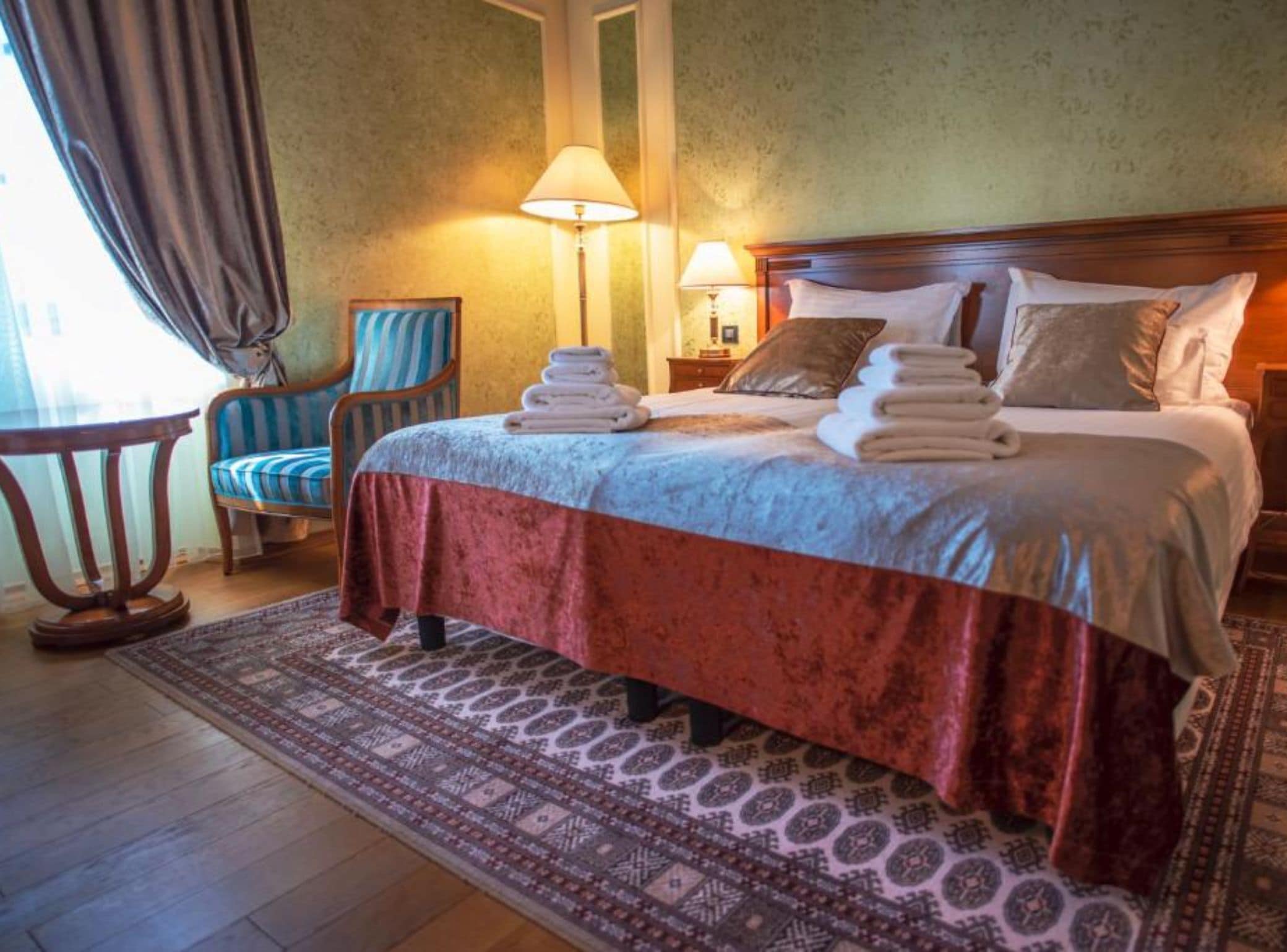 Une chambre d’hôtel avec un lit, deux lampes de chevet, une chaise et une table.