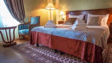 Une chambre d’hôtel avec un lit, deux lampes de chevet, une chaise et une table.