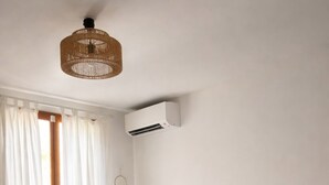 A bedroom with a large bed, wooden flooring, a hanging light fixture, and a window with curtains. - Villa with private pool between sea and mountains, quiet setting (Appietto)