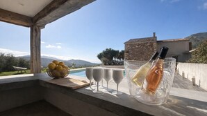 A balcony with a view of mountains, a bottle of champagne, and glasses on a table. - Villa with private pool between sea and mountains, quiet setting (Appietto)