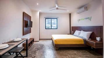 Una habitación de hotel moderna con cama, mesita de noche y escritorio con silla.