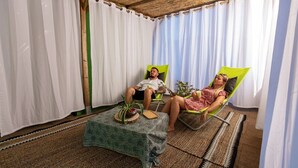 A room with two reclining chairs, a small table with a plant, and a woven floor mat. - ZEcamping 4* - espace aquatique de 2000m2 - proche cap d'Agde (Bessan)