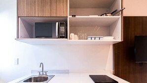 Eine moderne Küche mit integriertem Mikrowellenherd, Spüle und Arbeitsplatte.