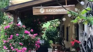 A rustic outdoor seating area with a sign reading 'SAVONNERIE.' - ZEcamping 3* toboggans dog friendly locatif 36m2 5 pers (Chézery-Forens)
