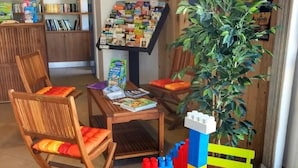 Lasten leikkialue, jossa on pöytä, tuoleja ja Lego-torni.