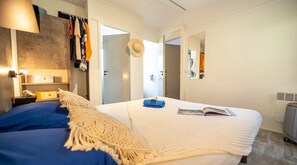 A bedroom with a bed, a bedside table, a lamp, a wardrobe, and a mirror. - ZEcamping 4 étoiles familial avec piscine couverte (Laroque-des-Albères)