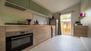 Une cuisine moderne équipée d’un four encastré, d’un four à micro-ondes et d’une cuisinière à gaz.