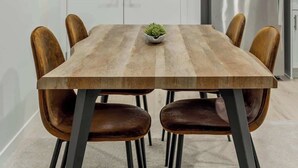 A dining area with a wooden table, leather chairs, and a modern kitchen in the background. - Arcade, Neon Lights, 70 min Banff , Local Coffee (Calgary)