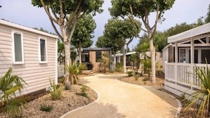 Un parque de casas móviles con varias viviendas de una sola planta, un camino central y jardines pequeños.