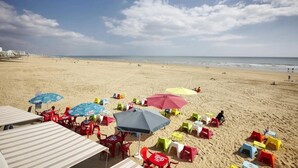 A beach with umbrellas, chairs, and tables. - ZEcamping 4* 1km plage piscine couverte chiens acceptés mobil-home TV (Saint-Jean-de-Monts)