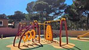 A playground with various play structures including swings, slides, and climbing frames. - ZEcamping 3 étoiles 200m plage animaux acceptés locatif TV clim 26m2 (Hyères)