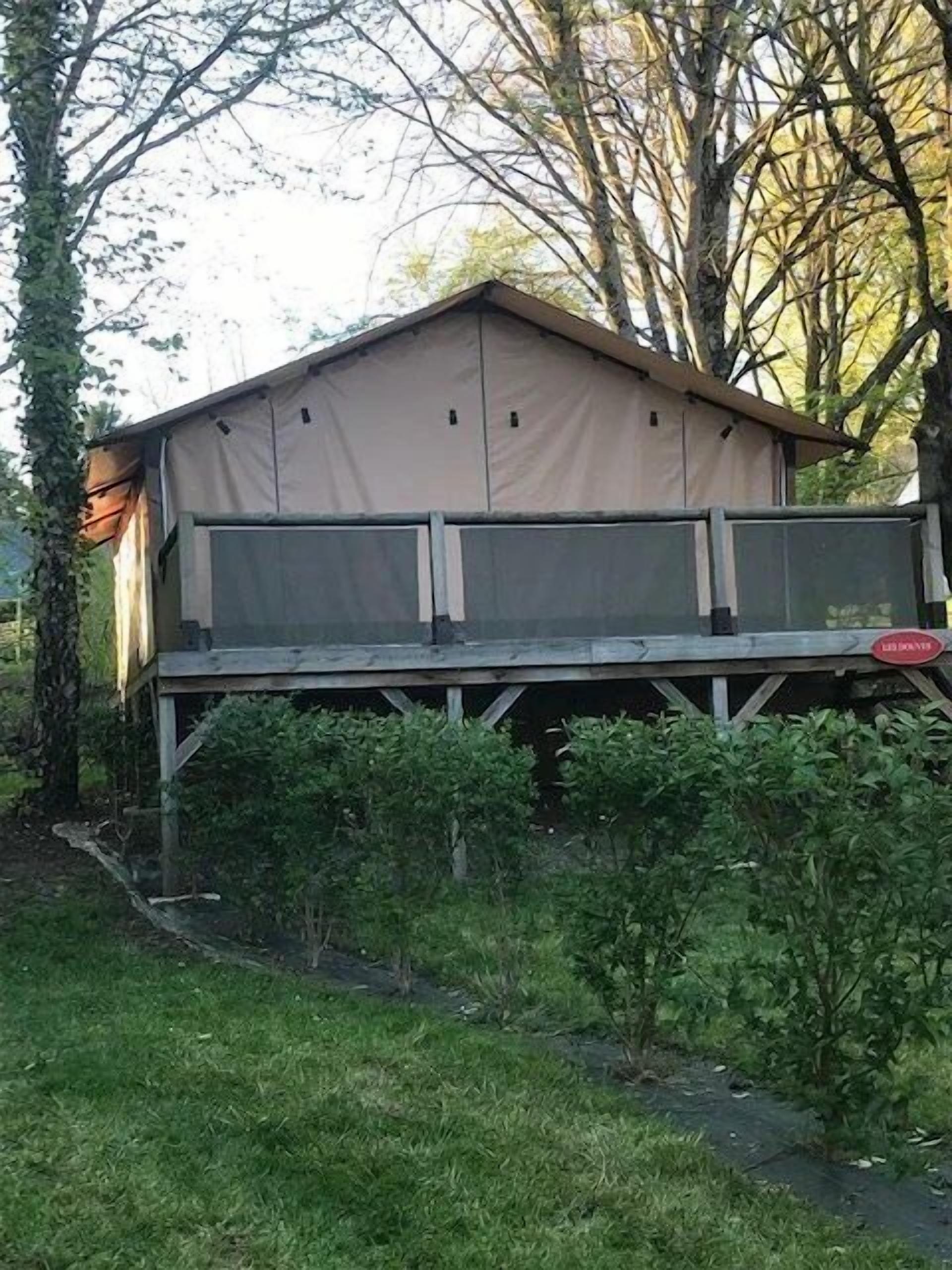Une cabane de plain-pied, composée de deux pièces, avec un toit plat et une petite terrasse.