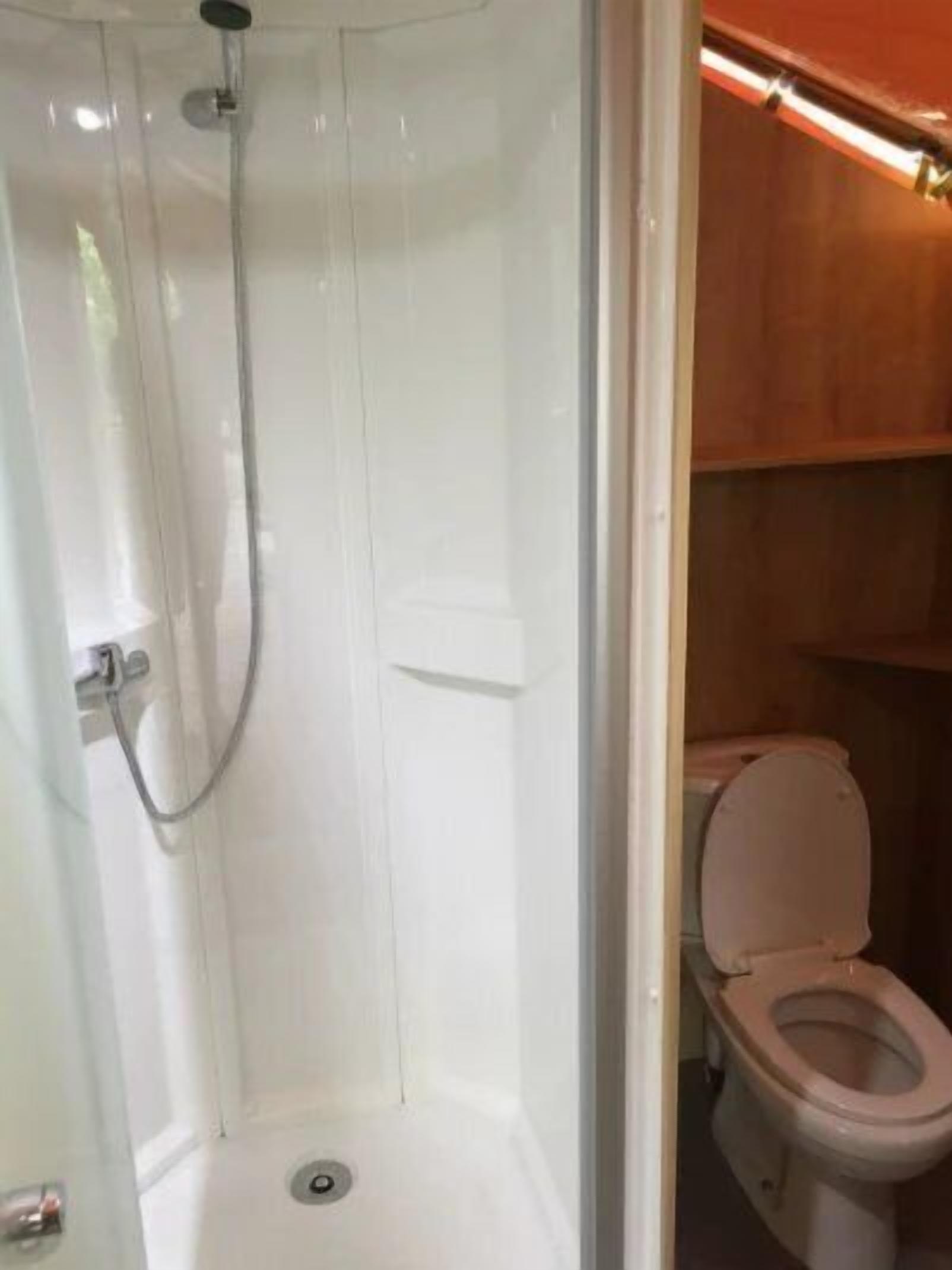 A bathroom with a shower, toilet, and a sink.