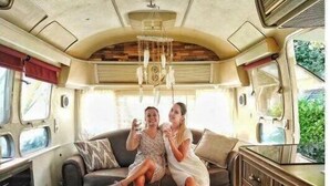 A cozy RV interior with a sofa, wooden coffee table, and a kitchen area. - ZEcamping 3 étoiles familial piscine chauffée locatif 16m2 2 pers (Hauterives)