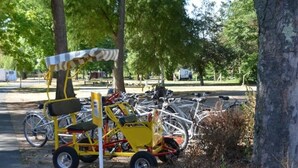 Un aparcamiento para bicicletas con un carro amarillo y una zona cubierta para sentarse.
