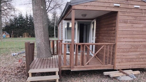 A wooden cabin with a porch and a door leading inside. - ZEcamping 3 étoiles piscine pet friendly club enfant tente 27m2 4 pers (Sauxillanges)