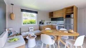 Une cuisine moderne avec des meubles en bois, une table à manger et des chaises blanches.