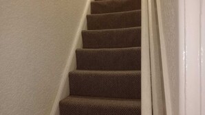 A carpeted staircase with white walls. - PapaJoe's Get-away! Just what you deserve
sleeps 8/2 toilets/6 min to Waterworld (Stoke-on-Trent)