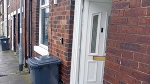 A narrow street with red brick houses, a white door, and a blue trash bin. - PapaJoe's Get-away! Just what you deserve
sleeps 8/2 toilets/6 min to Waterworld (Stoke-on-Trent)