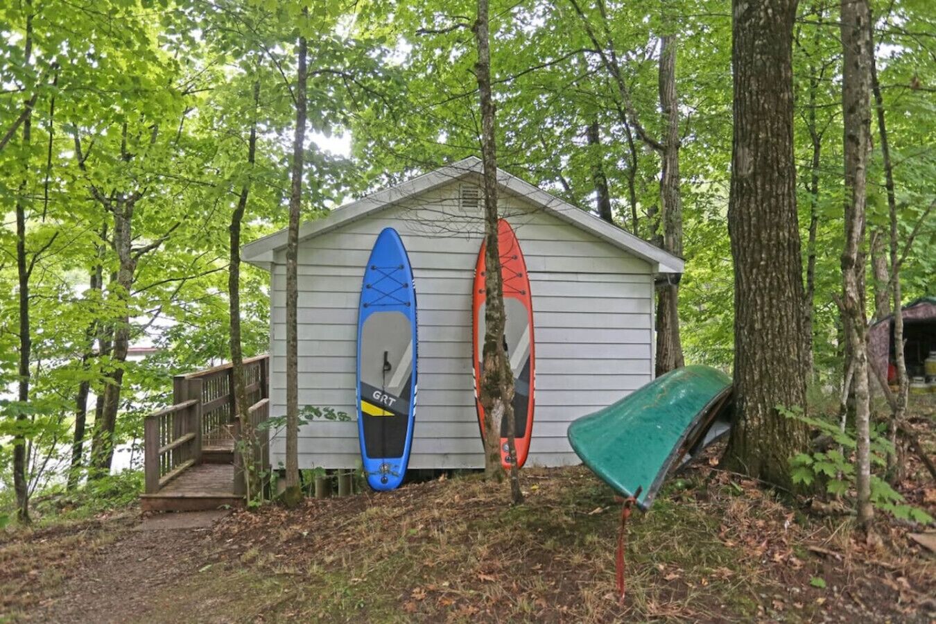 Une petite cabane avec deux kayaks fixés sur le côté.