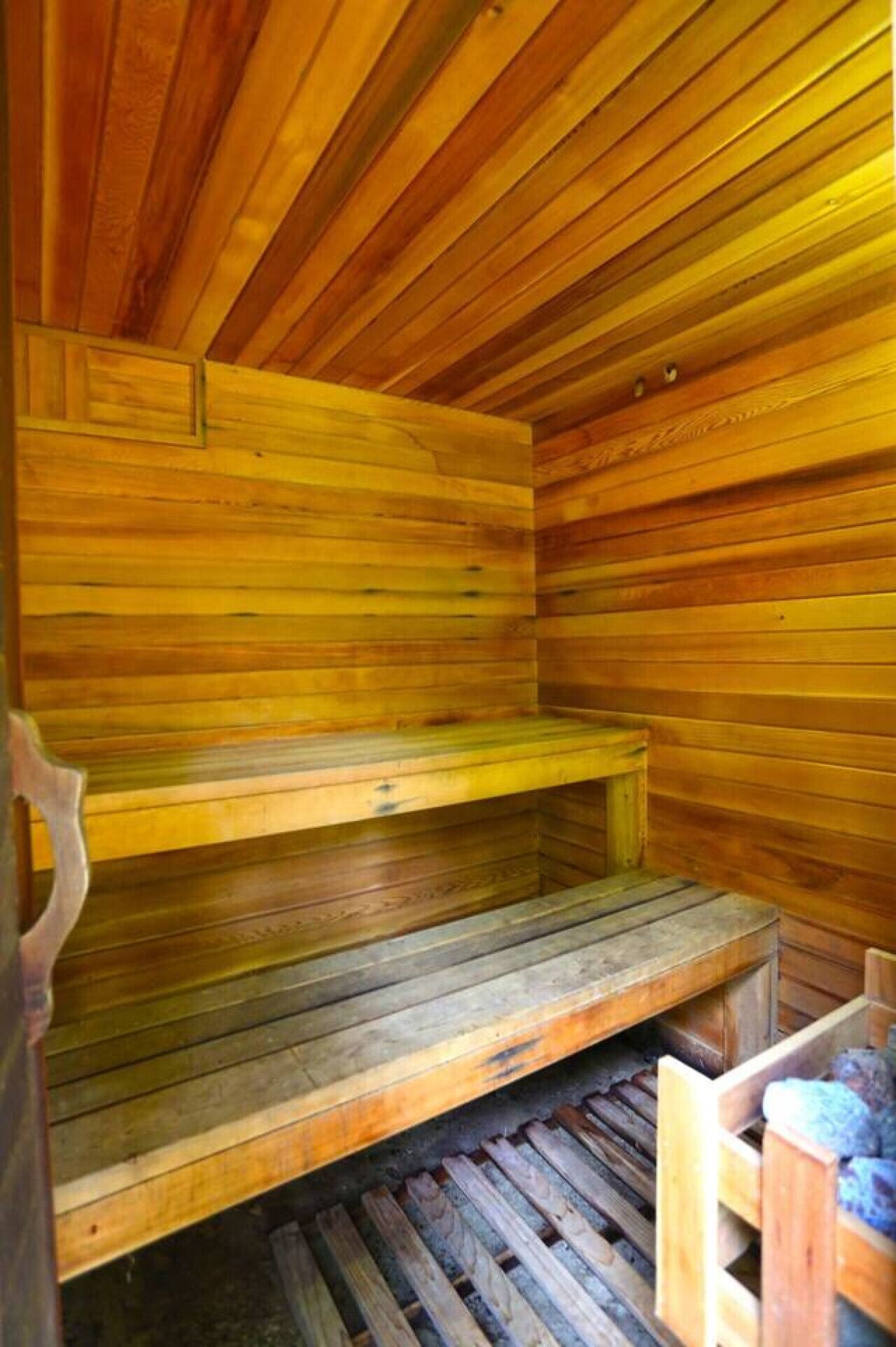 A wooden sauna with benches and steps.