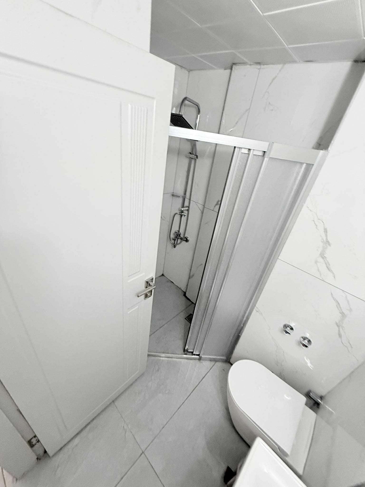 Ein Badezimmer mit Toilette, Dusche und einer Tür.