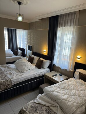 Ein Hotelzimmer mit zwei Betten, einem Nachttisch mit Fernbedienung und einem Spiegel.