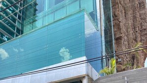 A modern building with a glass facade, a staircase leading to the entrance, and the number 807 displayed on the side. - Top Bed | Mixed Shared Room (Ciudad de México)