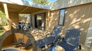 A covered outdoor area with a pool, lounge chairs, and a table. - ZEcamping 4* animé espace aquatique sauna hammam locatif TV LV BBQ (Aubigny-Les Clouzeaux)