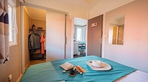 Ein Schlafzimmer mit Bett, Schrank, Badezimmer und einer Tür zu einem weiteren Raum.