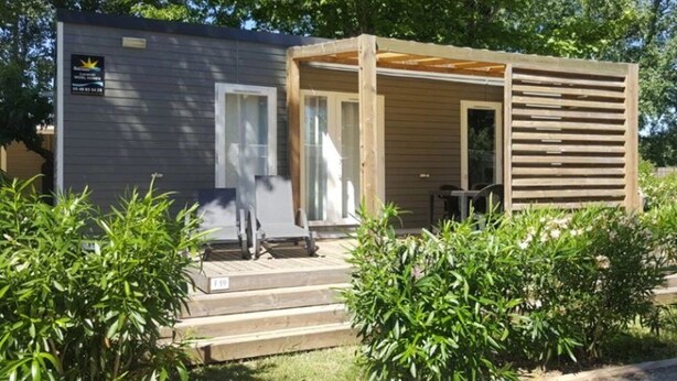 A small cabin with a wooden porch, a door, and a window. - Camping 4 étoiles - Parc aquatique - ccbahgb (Saint-Cyprien)
