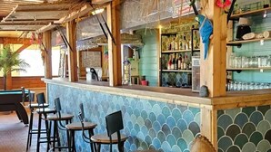 Eine Bar mit Theke, Hockstühlen und einer dekorativen Holzfigur.