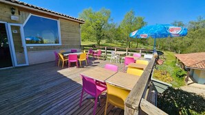 Eine Holzterrasse mit Sitzgelegenheiten und einem großen Sonnenschirm.