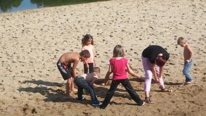 Uma praia arenosa com pessoas praticando atividades.