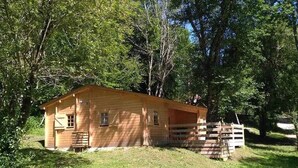A wooden cabin with a fenced yard, surrounded by trees. - Chalet 3 étoiles - Piscine  - ccbfeag (Mayrac)