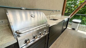 A stainless steel outdoor kitchen with a sink and a trash can. - Villa Del Porto #307 - Flat in Porto by Carpediem (Ipojuca)