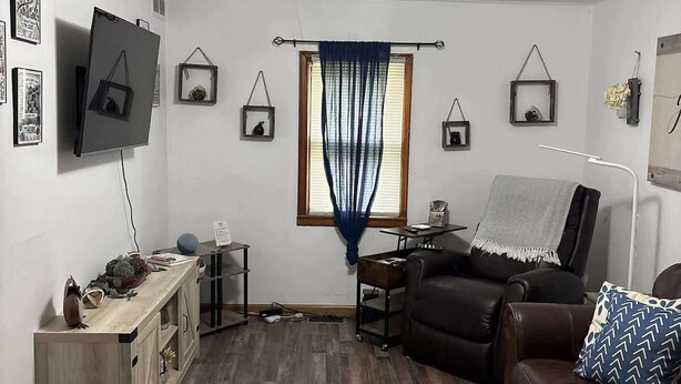 A living room with a sofa, a TV mounted on the wall, a wooden cabinet, and a patterned rug. - Pet-Friendly Home in Downtown Balaton (Balaton)