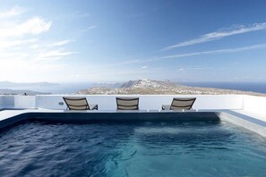 A rooftop infinity pool with three lounge chairs and a view of a mountainous landscape. - Villa Complex Aurivis, Divine Sea Views, Private Pool n Hot Tub, Furnished. (Santorini)