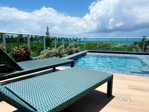 A poolside area with lounge chairs and a view of the ocean. - Cupe Garden #315 - Porto de Galinhas by Carpediem (Ipojuca)