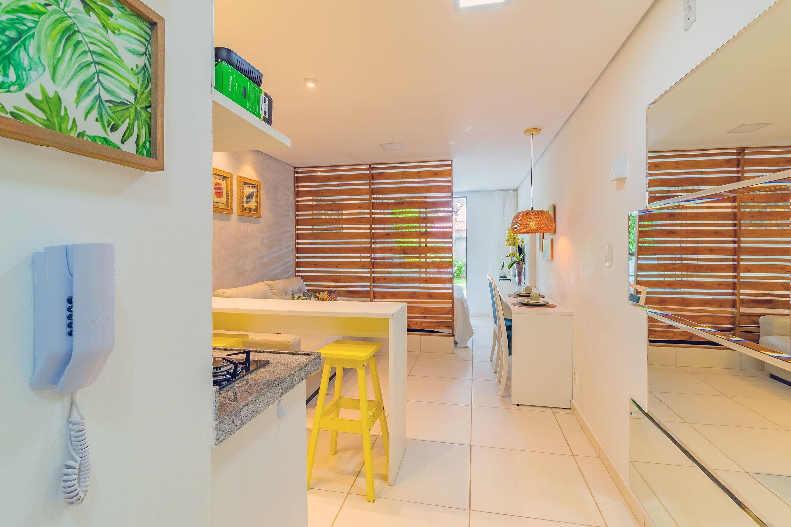 Una cocina moderna con un taburete amarillo, una encimera blanca y una estufa.