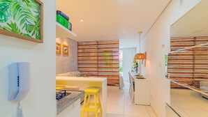 Una cocina moderna con un taburete amarillo, una encimera blanca y una estufa.