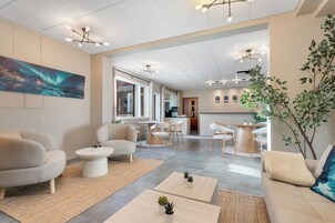 Una sala de estar moderna con sofás, mesas de centro y un comedor.