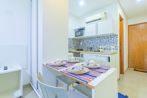 A compact kitchen with white cabinets, a microwave, and a tiled backsplash. - Manawa Beach #a33 - Porto de Galinhas By Carpediem (Ipojuca)