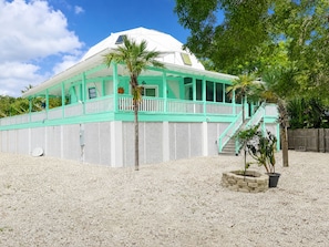 A white building with a green roof and a covered porch. - Peaceful Waterfront Tropical Paradise (Monroe County)