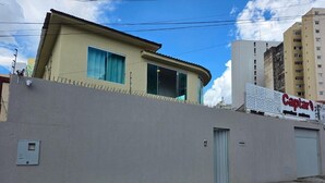 A building with a beige facade, a blue door, and a sign for "Captiva". - Cerrado hostel (Goiânia)