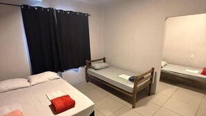 A room with two beds, a window with curtains, and a ceiling light. - Cerrado hostel (Goiânia)