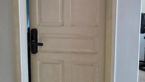 A closed door with a number plate '03' and a black handle. - Cerrado hostel (Goiânia)